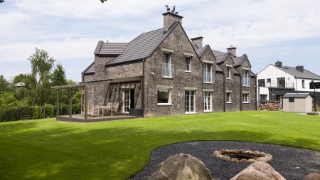 Rezydencja z elewacją z kamienia naturalnego; przykład luksusowego wykończenia domu przez firmę New-House.