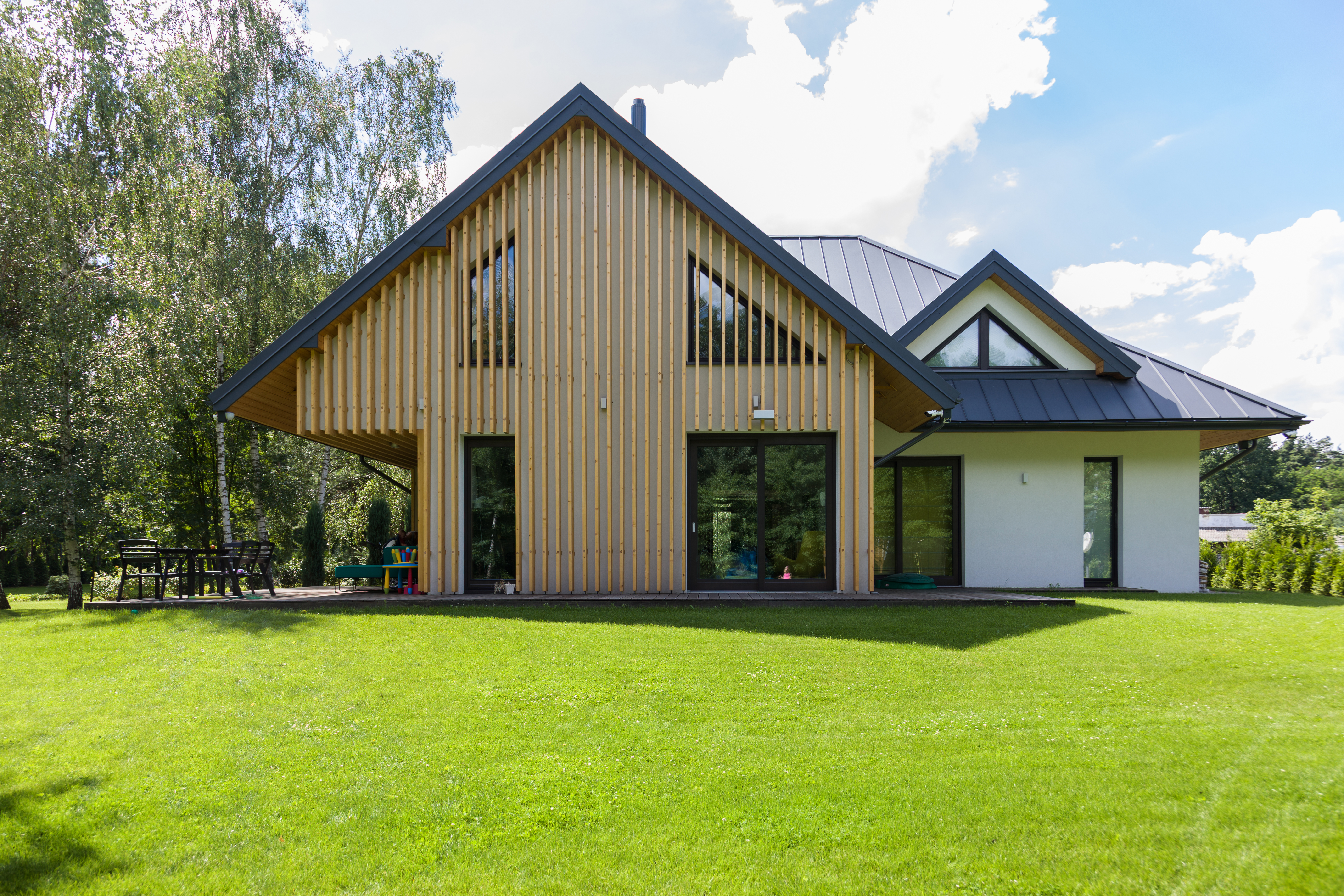 Nowoczesny biały dom z drewnianą elewacją, wybudowany przez firmę New-House.