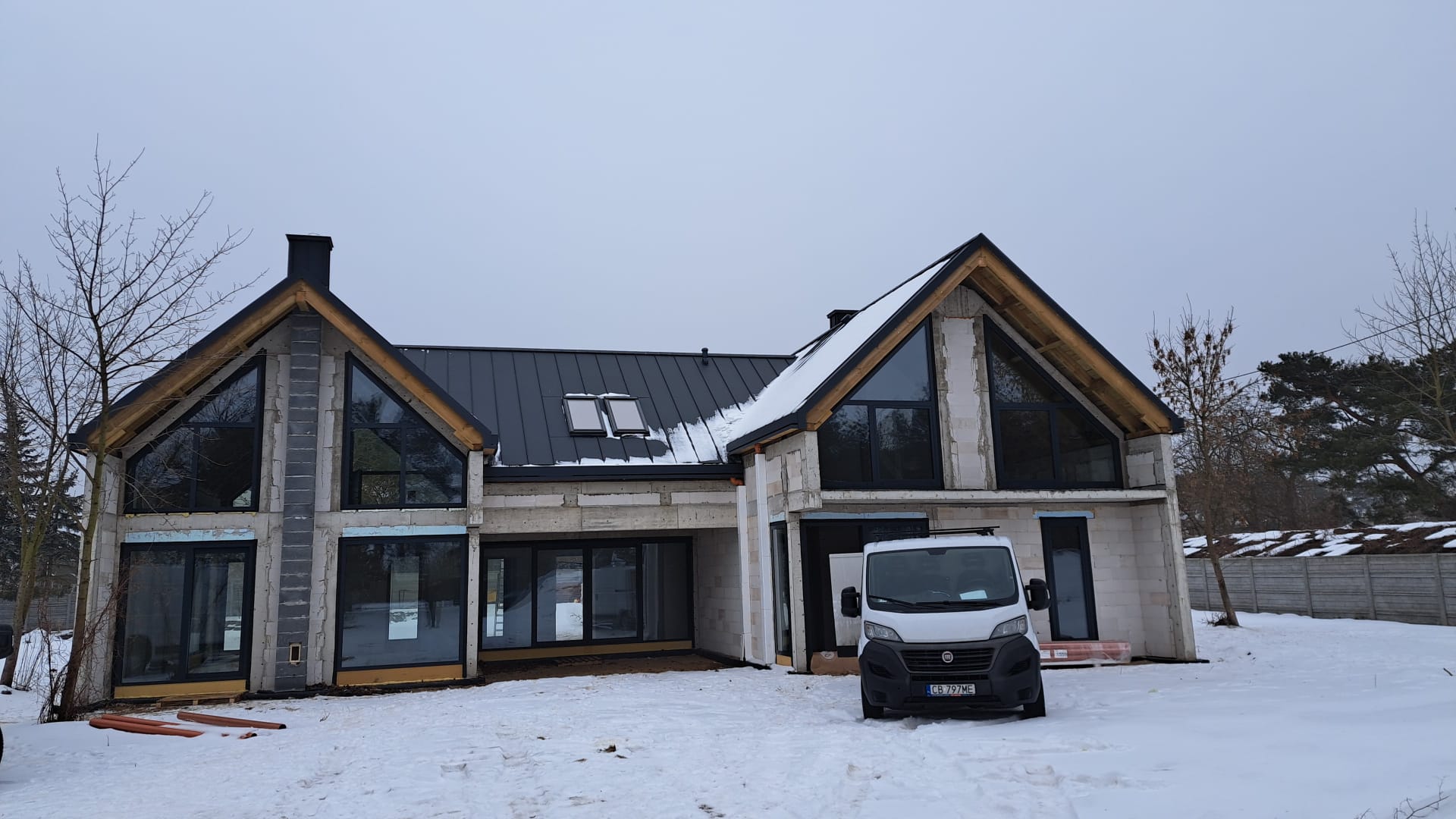 Front nowoczesnego domu z dużymi oknami i dwustanowiskowym garażem, wykonany przez generalnego wykonawcę New-House.