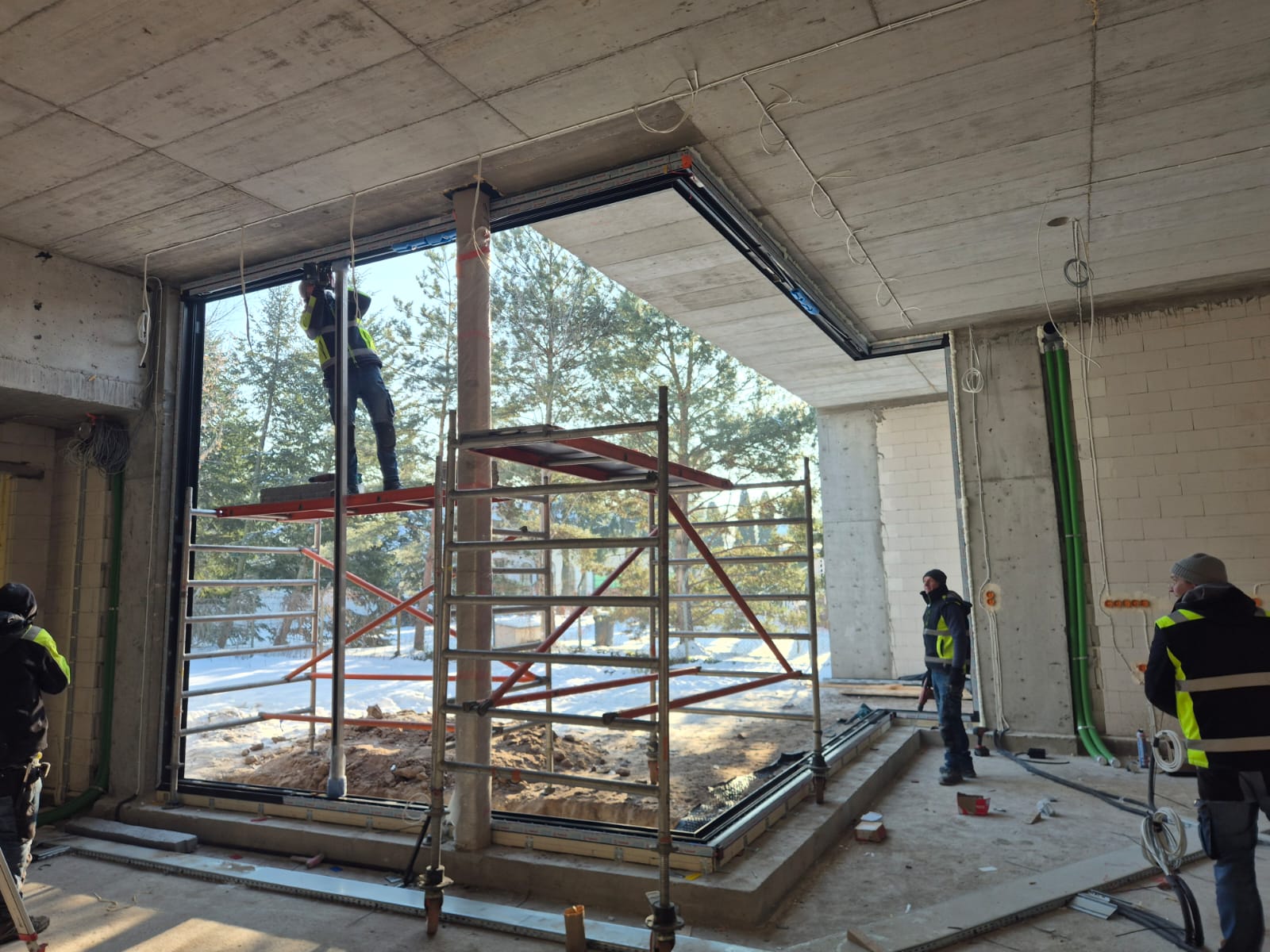 Fachowcy New-House podczas montażu wielkoformatowych okien; element kompleksowej budowy domu uwzględniający precyzyjny kosztorys wykonawczy.